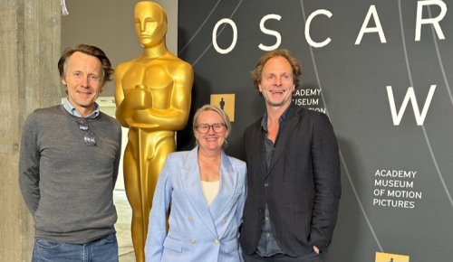 Foto: tre personer står foran en stor kopi av Oscar-statuetten, Nattrikken-regissør Eirik Tveiten og produsentene Heidi Arnesen og Gaute Lid Larssen  